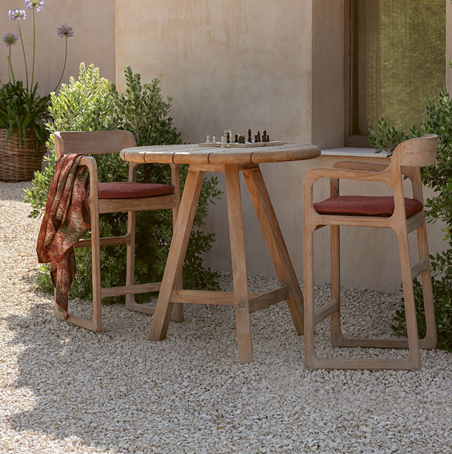 Der runde Outdoor Bartisch Anton von Gommaire besteht aus Teakholz und überzeugt durch sein schlichtes Design.