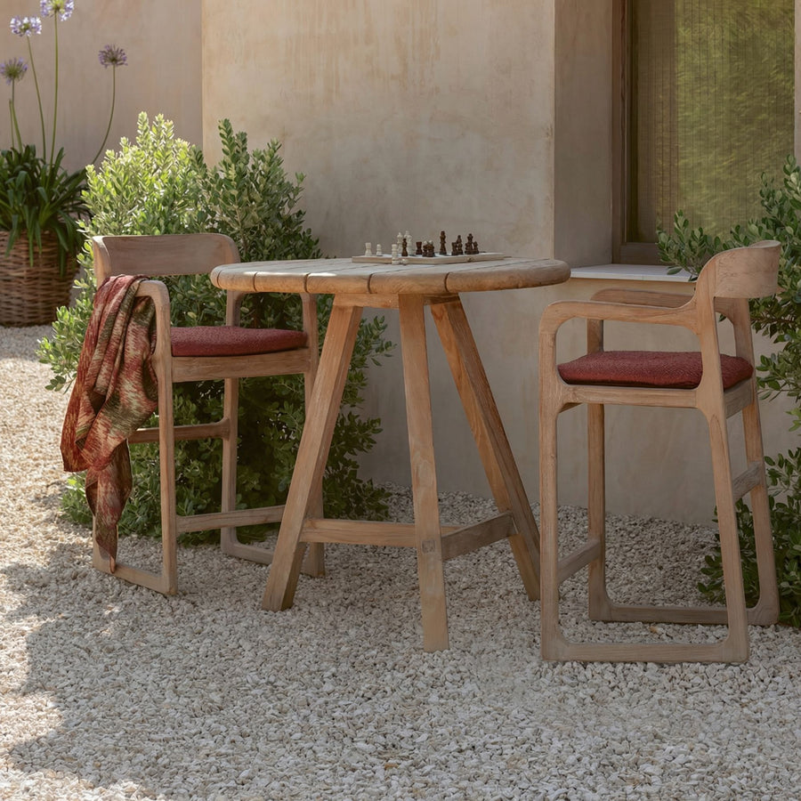 Der runde Outdoor Bartisch Anton von Gommaire besteht aus Teakholz und überzeugt durch sein schlichtes Design