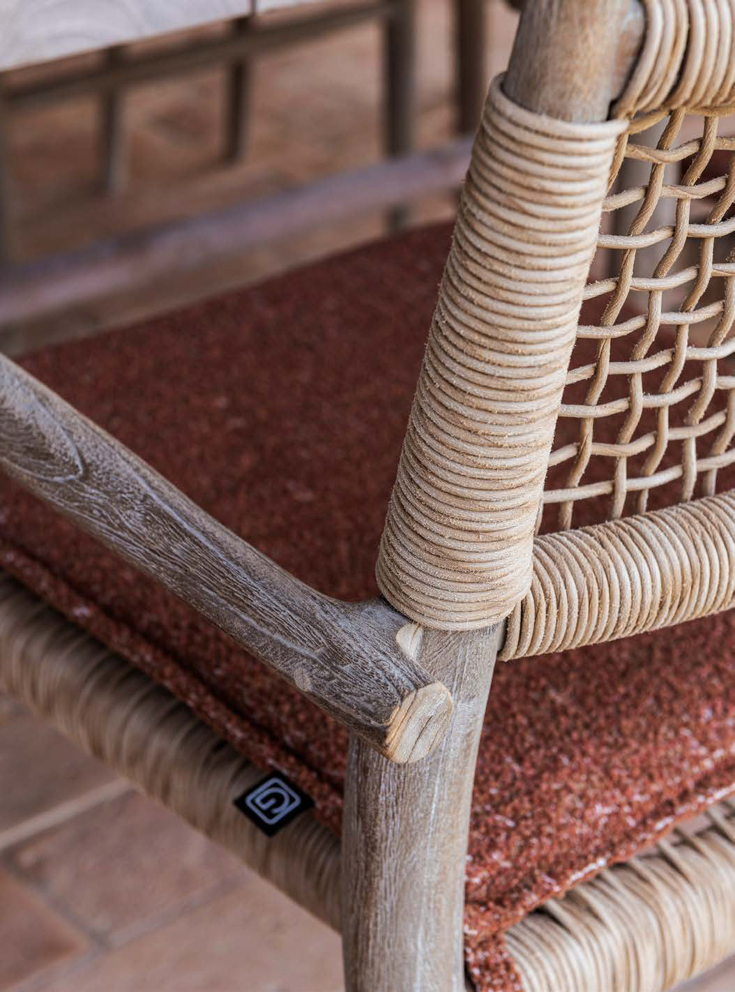 Stapelbarer Armlehnenstuhl Mieke aus Teakholz und PE Wicker in Sand.