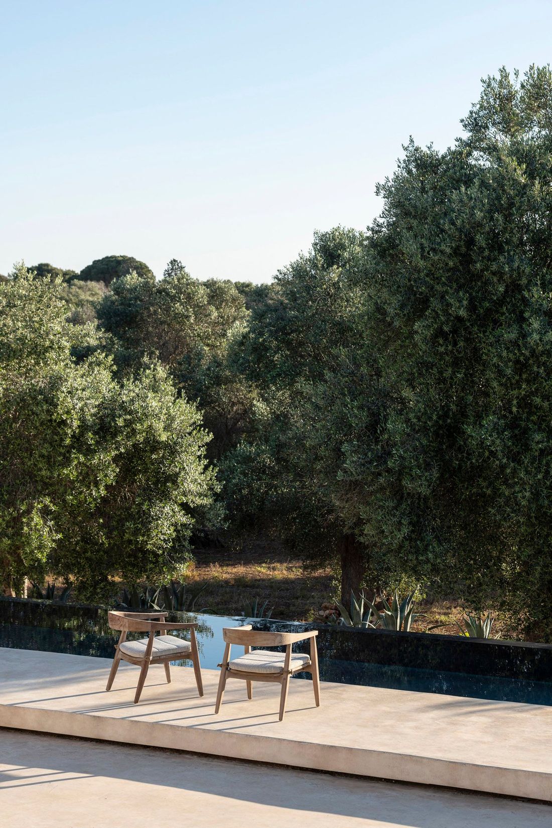 Armlehnenstuhl Faye Easy Chair low aus Teakholz in natürlichem Grau von Gommaire, ideal für Outdoor-Terrassen.