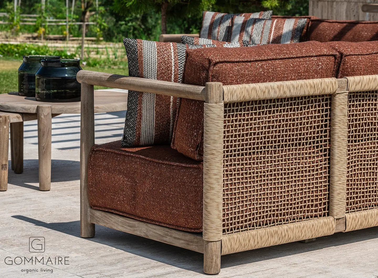 Gommaire Outdoor Ecksofa Mieke mit Ktextout Tessu 03 in einem landschaftlich gestalteten Garten.