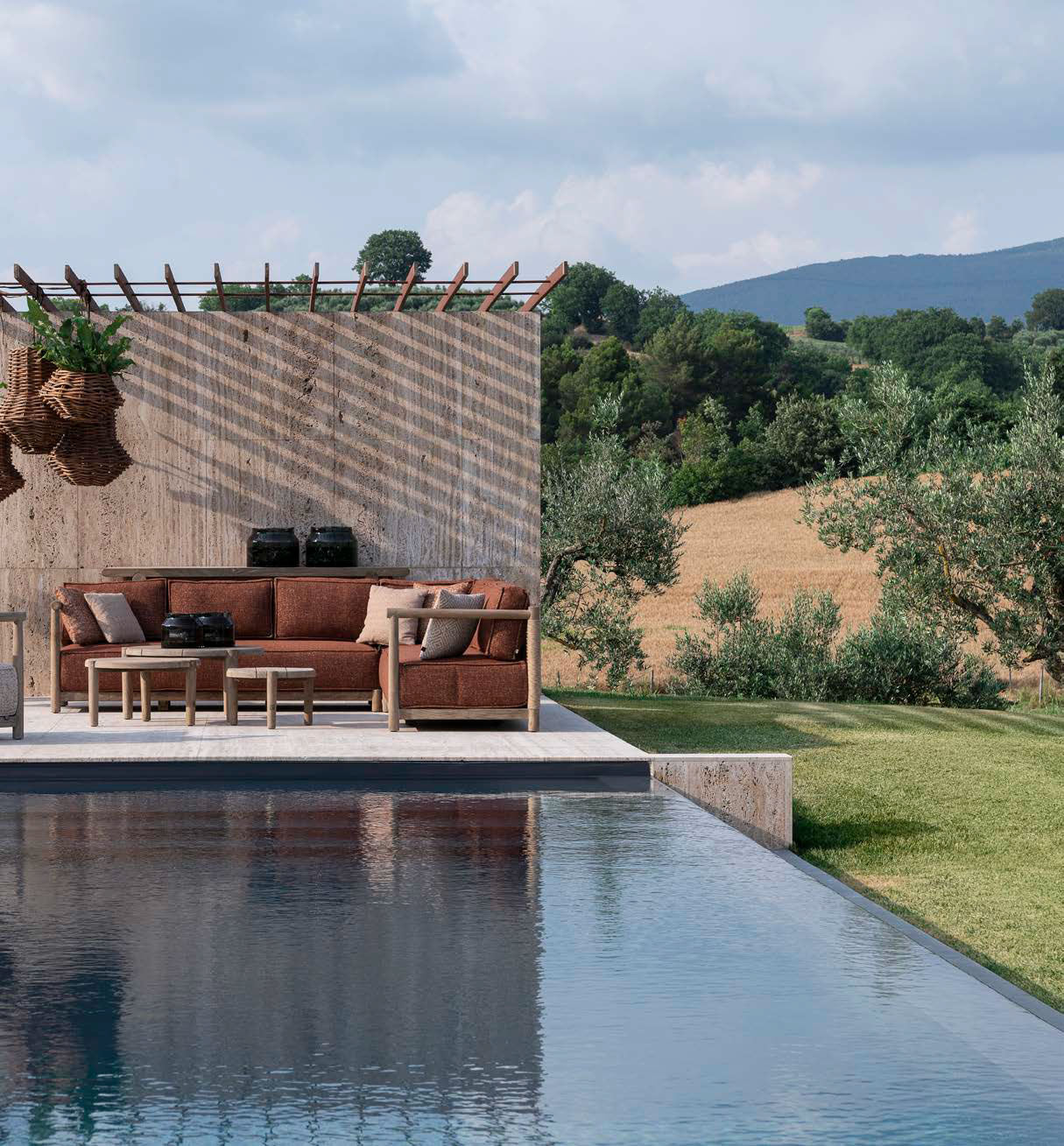 Gommaire Outdoor Ecksofa Mieke mit Ktextout Tessu 03 in einem landschaftlich gestalteten Garten.