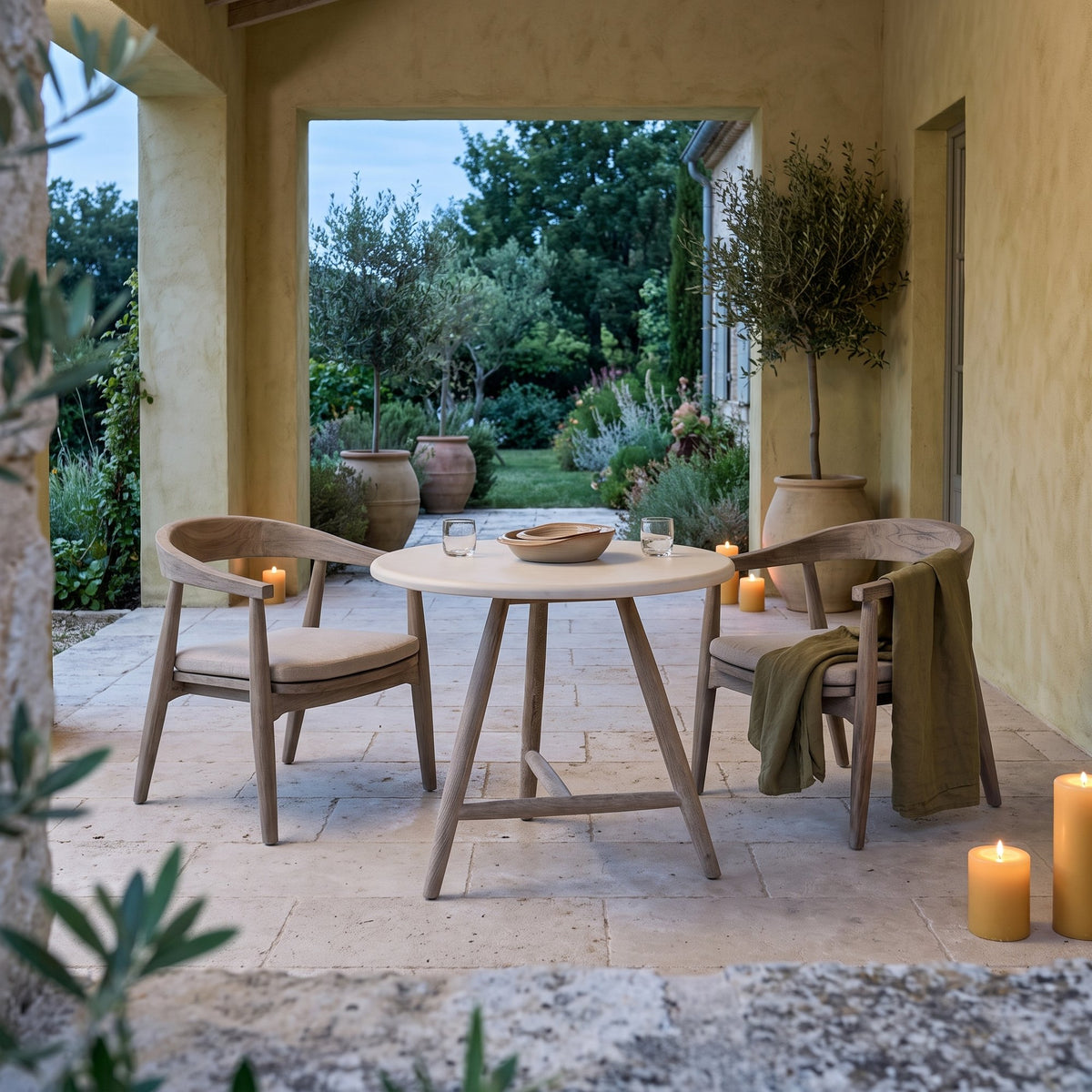 Bistrotisch Faye rund Beton Teak Natural Grey Low von Gommaire, Beton und Teak Natural Grey, Ø 75 × H 69 cm, Ambiente mit Sesseln Faye und Schale Ali in der Loggia