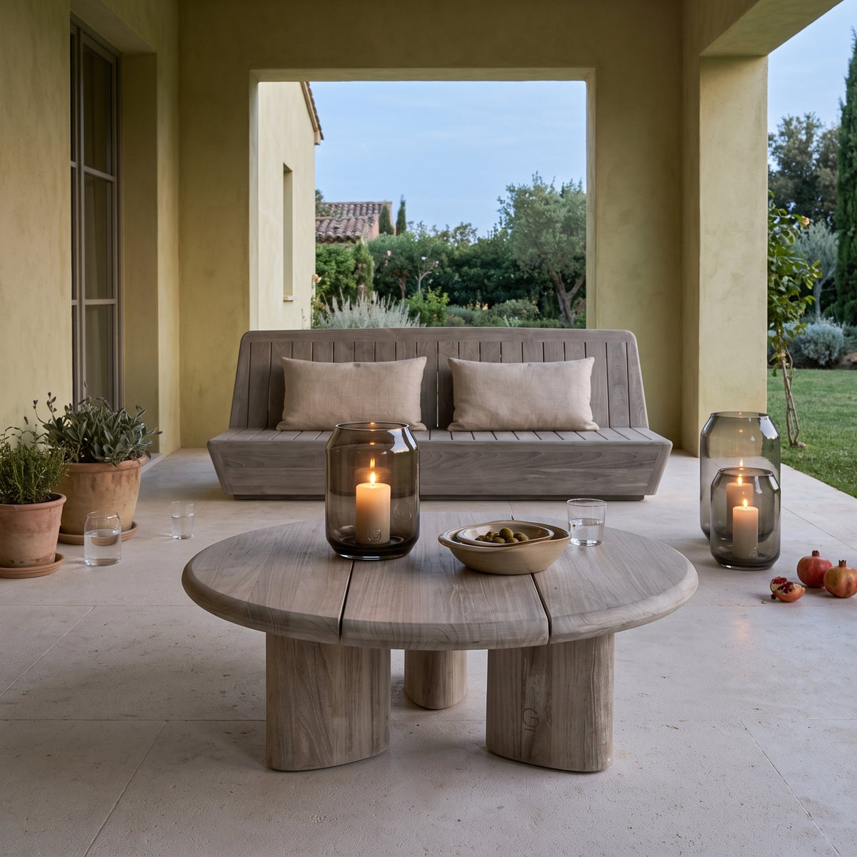Couchtisch Imen rund Teak Natural Grey Large von Gommaire, Teak Natural Grey, Ø 80 × H 28 cm, vor dem Outdoor Sofa Jules mit Windlicht Daniel und Schale Ali in der Loggia