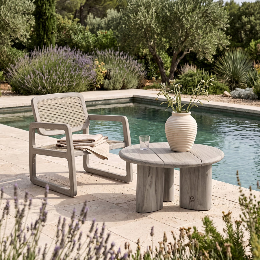Couchtisch Imen rund Teak Natural Grey Small von Gommaire, Teak Natural Grey, Ø 65 × H 35 cm, neben dem Loungesessel Sally Open Weave mit Vase Simon am Pool