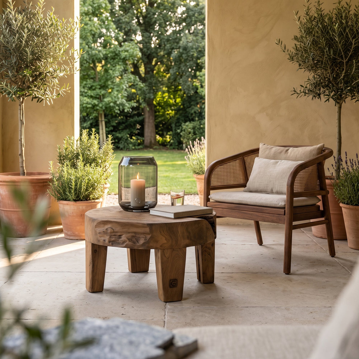 Couchtisch Samba Teakwurzel Emas Brown Large von Gommaire, Teakwurzel Emas Brown, Ø 50 × H 35 cm, Interiorbild neben dem Outdoor Sessel Imen mit Windlicht Daniel auf der Gartenterrasse