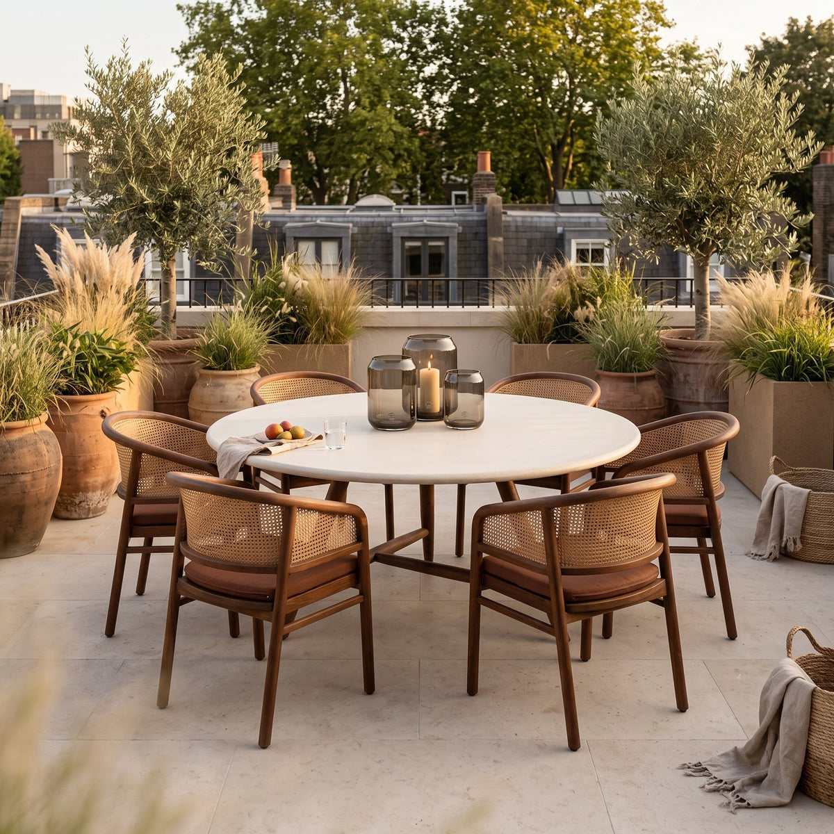 Esstisch Faye rund Beton Teak Emas Brown XL von Gommaire, Beton und Teak Emas Brown, Ø 170 × H 76 cm, Ambiente mit Armlehnenstühlen Imen und Windlicht Daniel auf der Dachterrasse