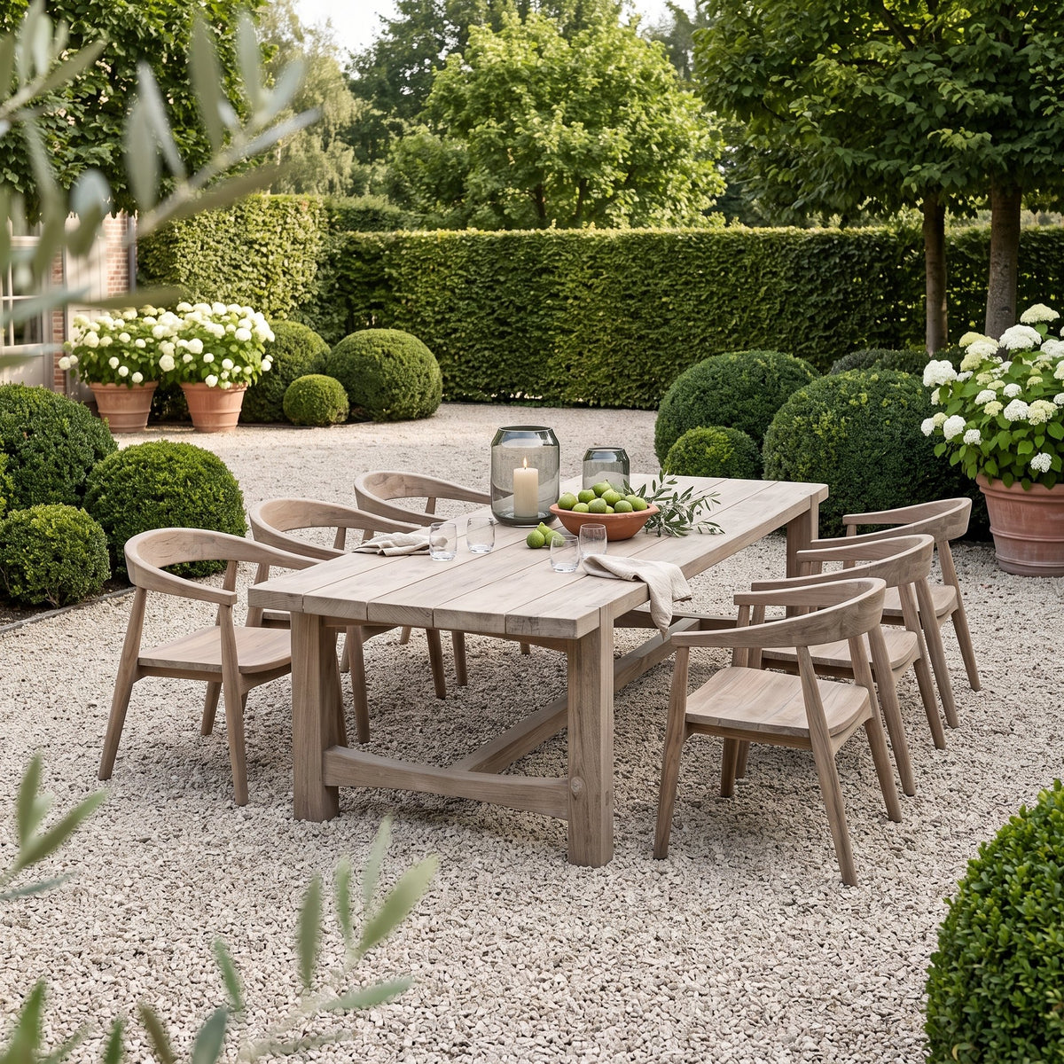 Esstisch Jacoba Small Teak Natural Grey Low von Gommaire, Teak Natural Grey, 270 × 102 × H 69 cm, Interiorbild mit Sesseln Faye und Windlicht Daniel im Kiesgarten
