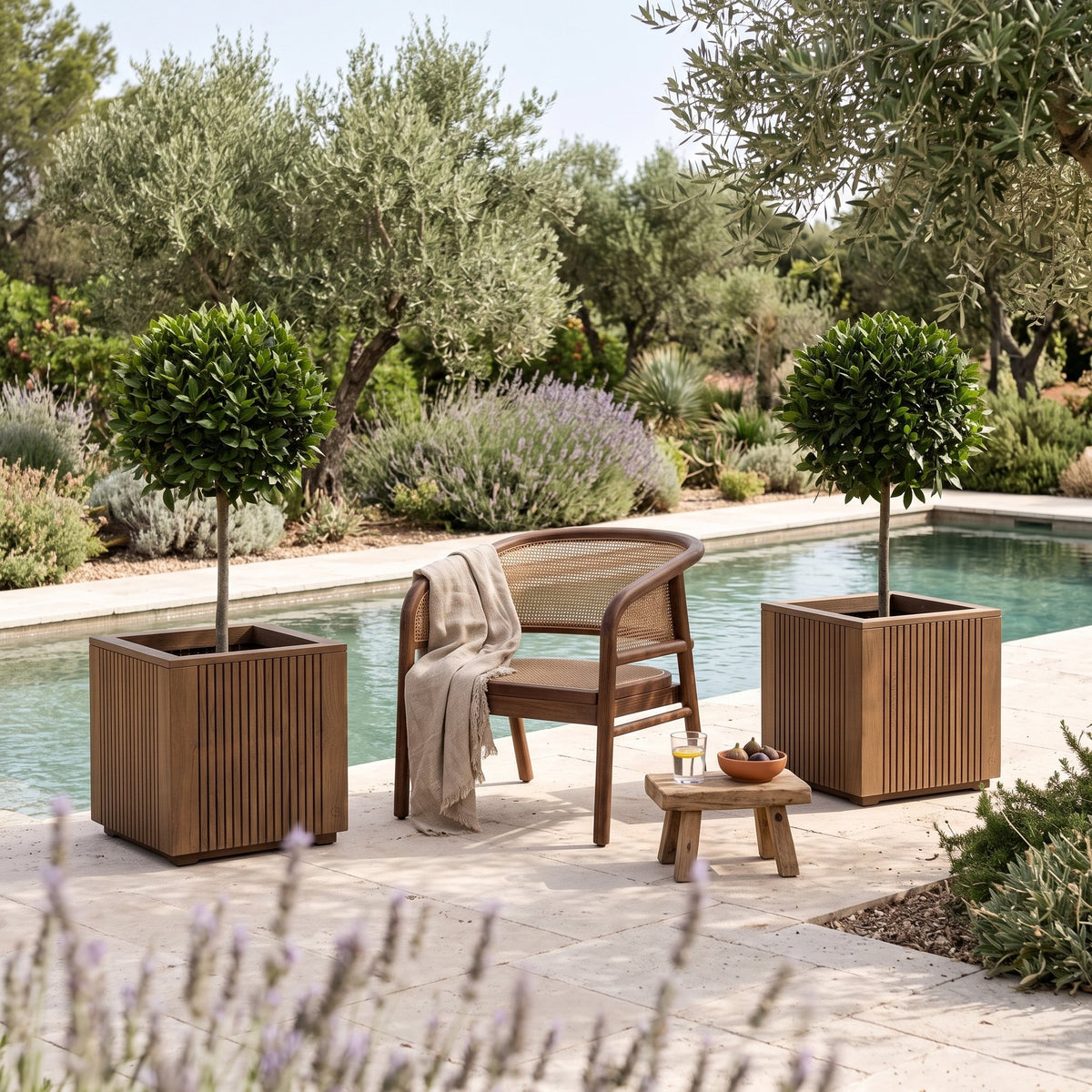 Pflanzkübel Nora Teak Emas Brown Large von Gommaire, Teak Emas Brown, 60 × 60 × H 60 cm, zwei Kübel neben einem Outdoor Sessel Imen am Pool