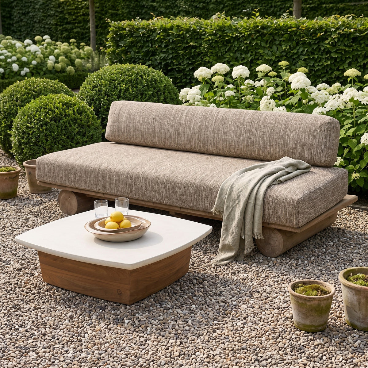 Sofa Edge Teak Emas Brown von Gommaire mit Kissenset, Teak Emas Brown und PE-Rattan Antique Weed, B 240 × T 98 × H 72 cm, mit Couchtisch Boa Teak Emas Brown mit Betonplatte Large und Schale Ali im Kiesgarten