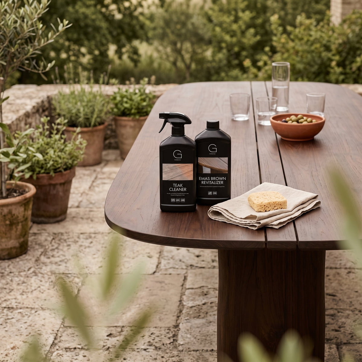 Teak Pflegeset Starterkit Emas Brown von Gommaire, Teak Cleaner und Teak Revitalizer Emas Brown, je 1 Liter, 2 × 1 Liter, auf dem Esstisch Dita Rectoval Emas Brown
