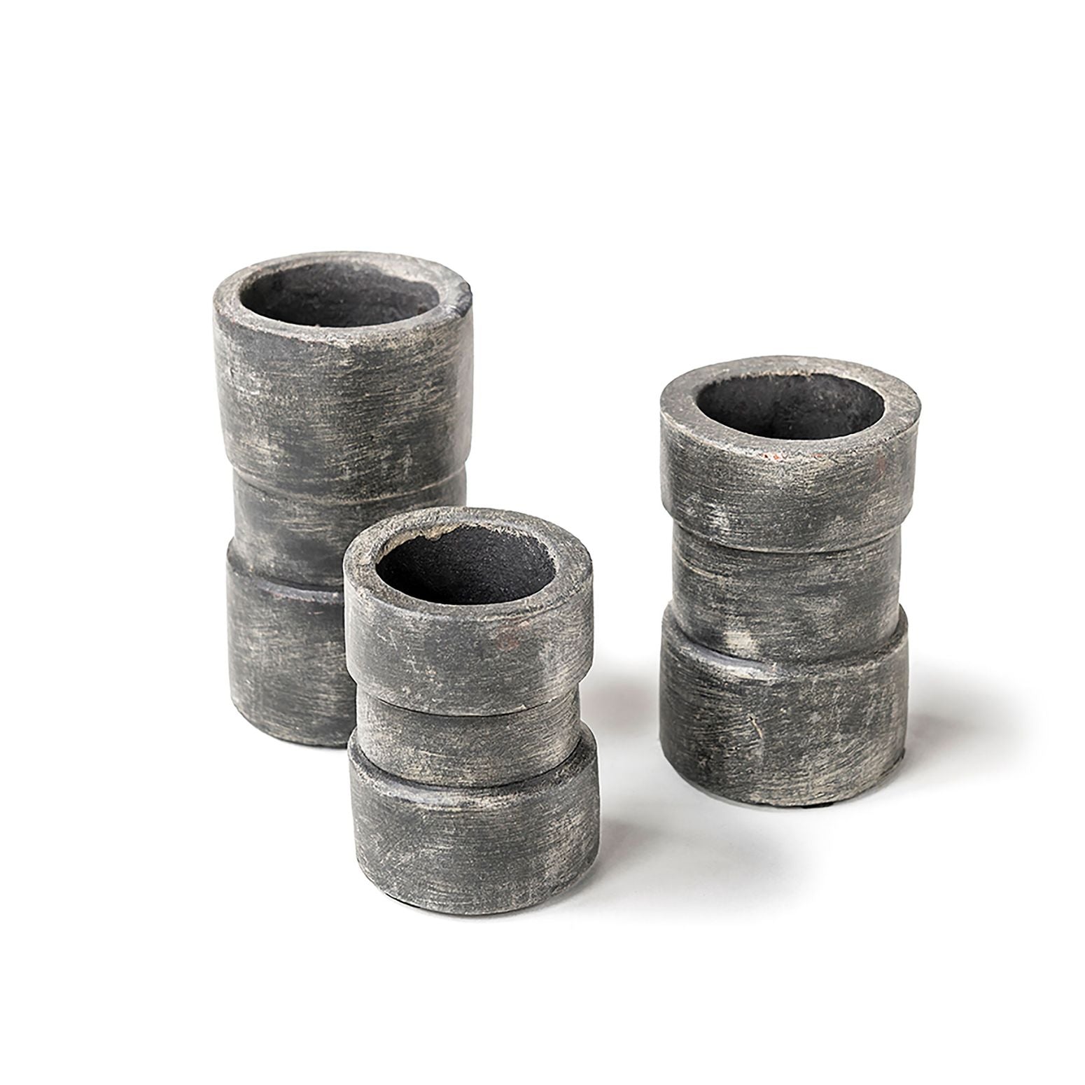 Teelichthalter-Set aus Terracotta in rauchig-patinierter Optik, bestehend aus drei verschiedenen Größen auf einem weißen Hintergrund