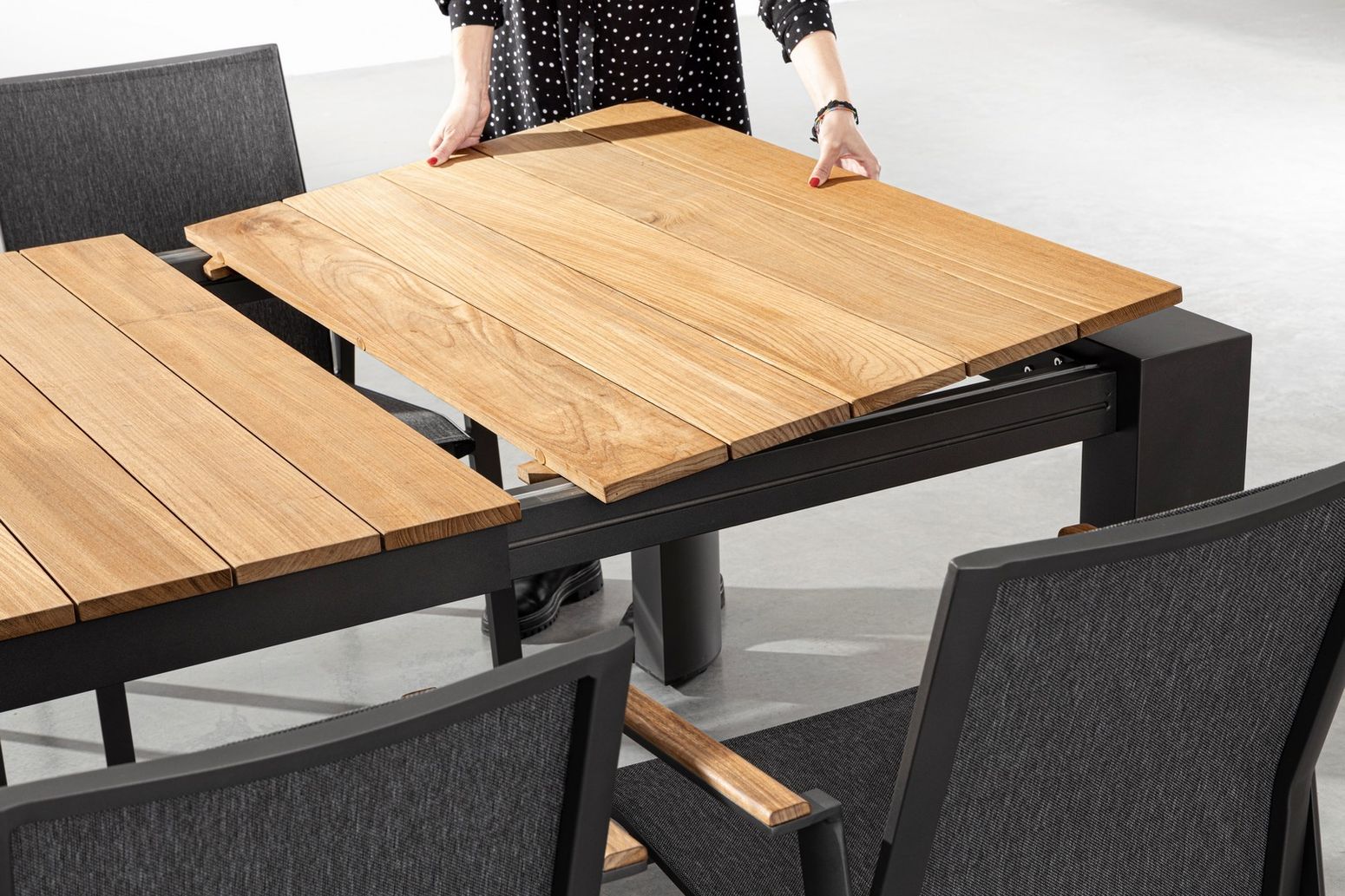 Detailansicht des Esstischs Cameron XXL in Schwarz mit der Mechanik der Auszugsfunktion und den verstellbaren Kunststofffüßen.