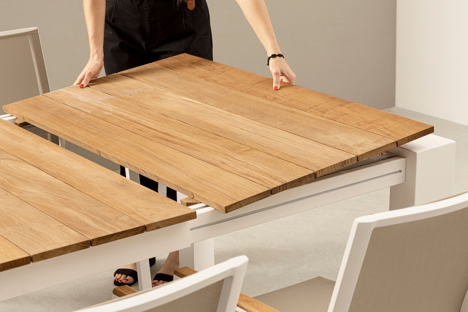 Detailansicht des Esstischs Cameron XXL in Weiß mit der Mechanik der Auszugsfunktion und den verstellbaren Kunststofffüßen.