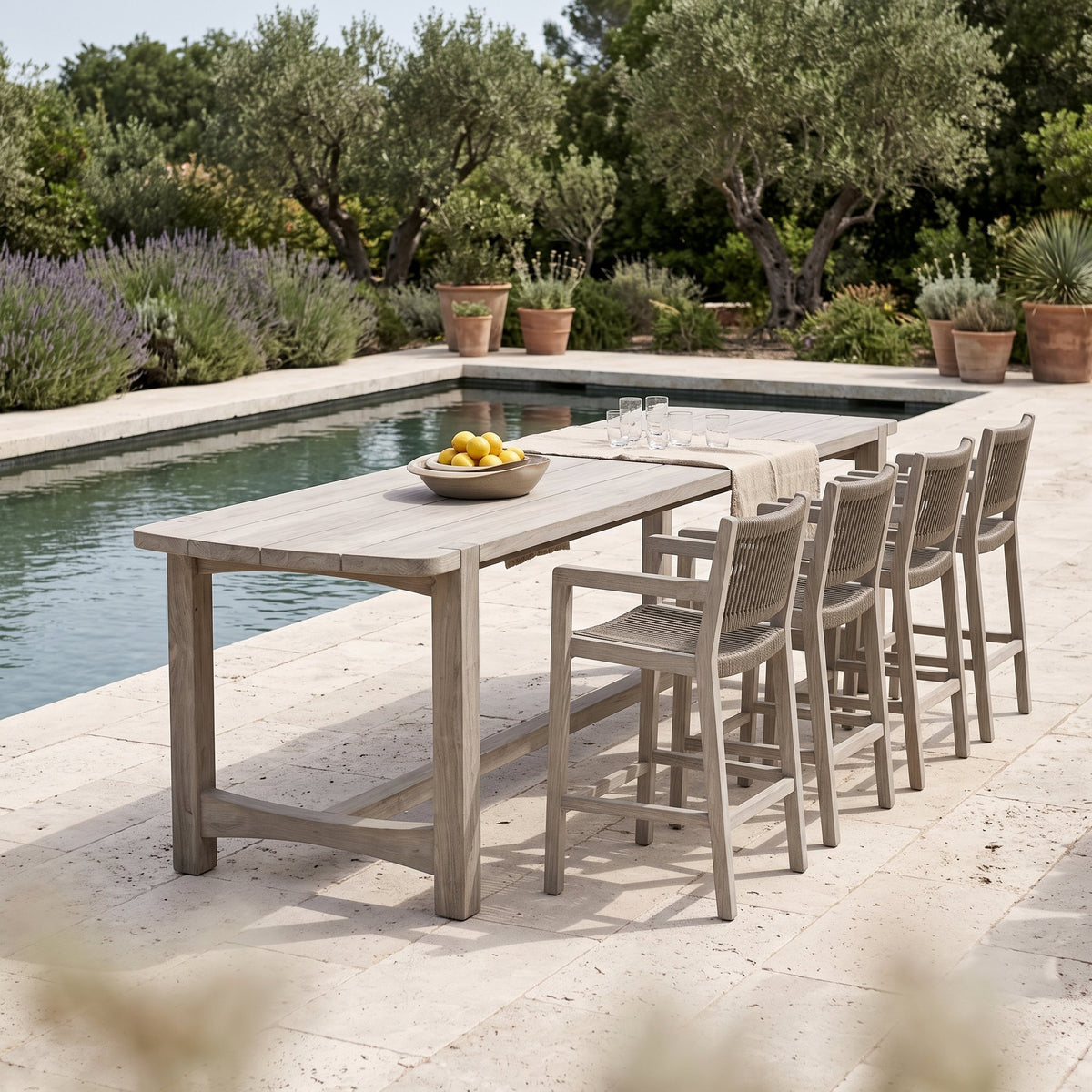 Bartisch Jacoba Teak Natural Grey von Gommaire, Teak Natural Grey, 300 × 97 × H 95 cm, mit Barstühlen Mario mit Armlehnen und Schale Ali am Pool