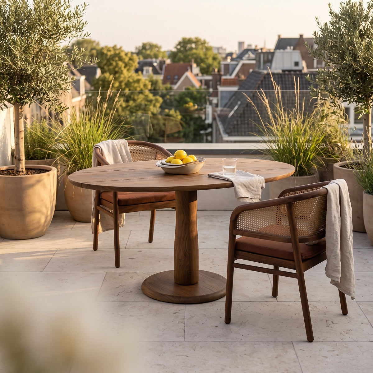 Bistrotisch Dita Oval Teak Emas Brown von Gommaire, Teak Emas Brown, 120 × 86 × H 76 cm, mit Armlehnenstühlen Imen und Schale Ali auf der Dachterrasse