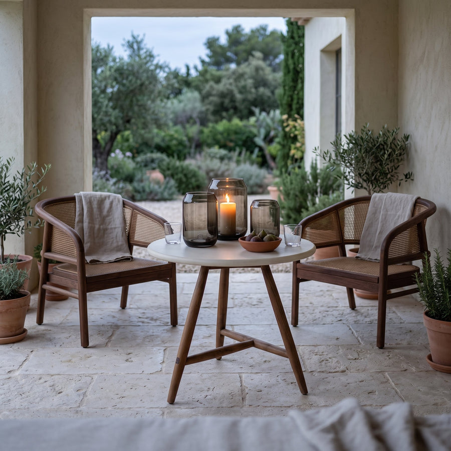 Bistrotisch Faye rund Beton Teak Emas Brown Low von Gommaire, Beton und Teak Emas Brown, Ø 75 × H 69 cm, Interiorbild mit Outdoor Sesseln Imen und Windlicht Daniel in der Loggia