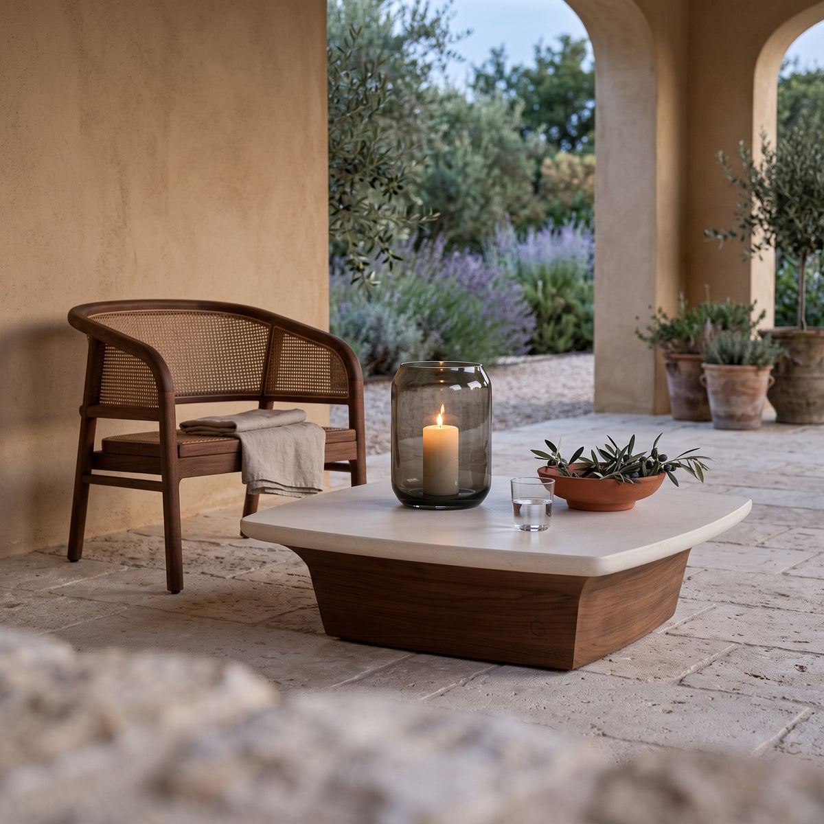 Couchtisch Boa Teak Emas Brown mit Betonplatte Small von Gommaire, Teak Emas Brown und Beton, 75 × 75 × H 22 cm, neben einem Outdoor Sessel Imen mit Windlicht Daniel in der Loggia