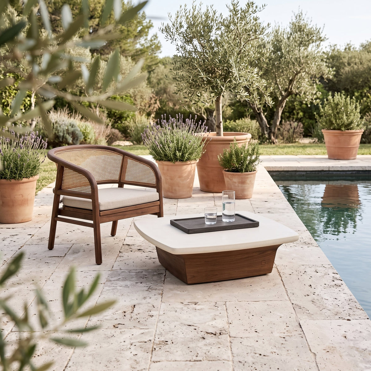 Couchtisch Boa Teak Emas Brown mit Betonplatte Small von Gommaire, Teak Emas Brown und Beton, 75 × 75 × H 22 cm, neben einem Outdoor Sessel Imen mit Tablett Mila am Pool