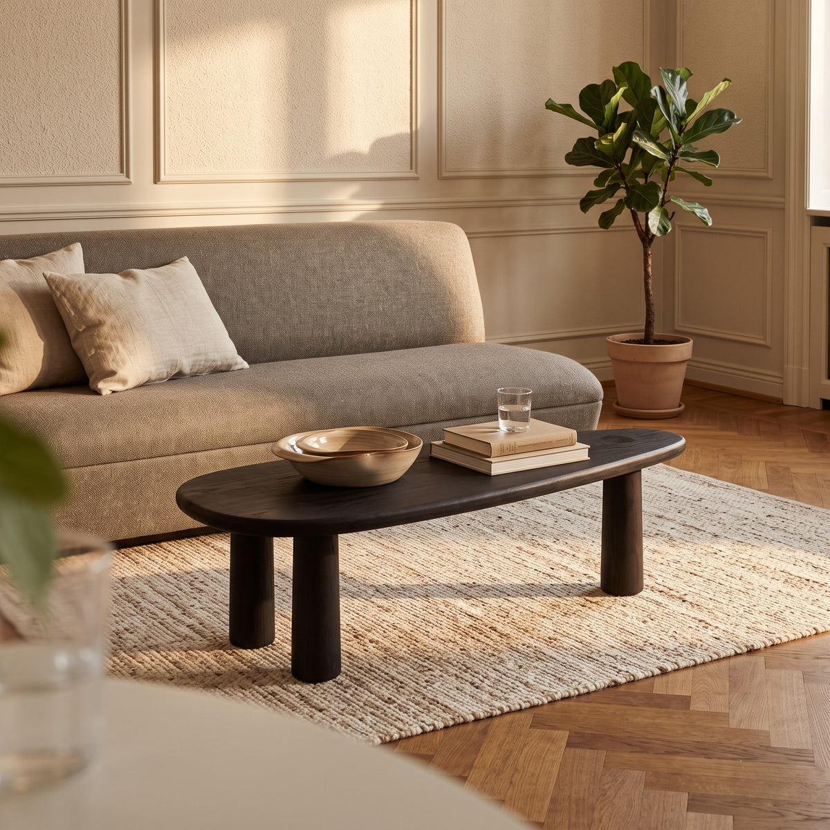 Couchtisch May Teak Fumé von Gommaire vor dem Sofa Jules Moss mit Schale Ali im Wohnzimmer