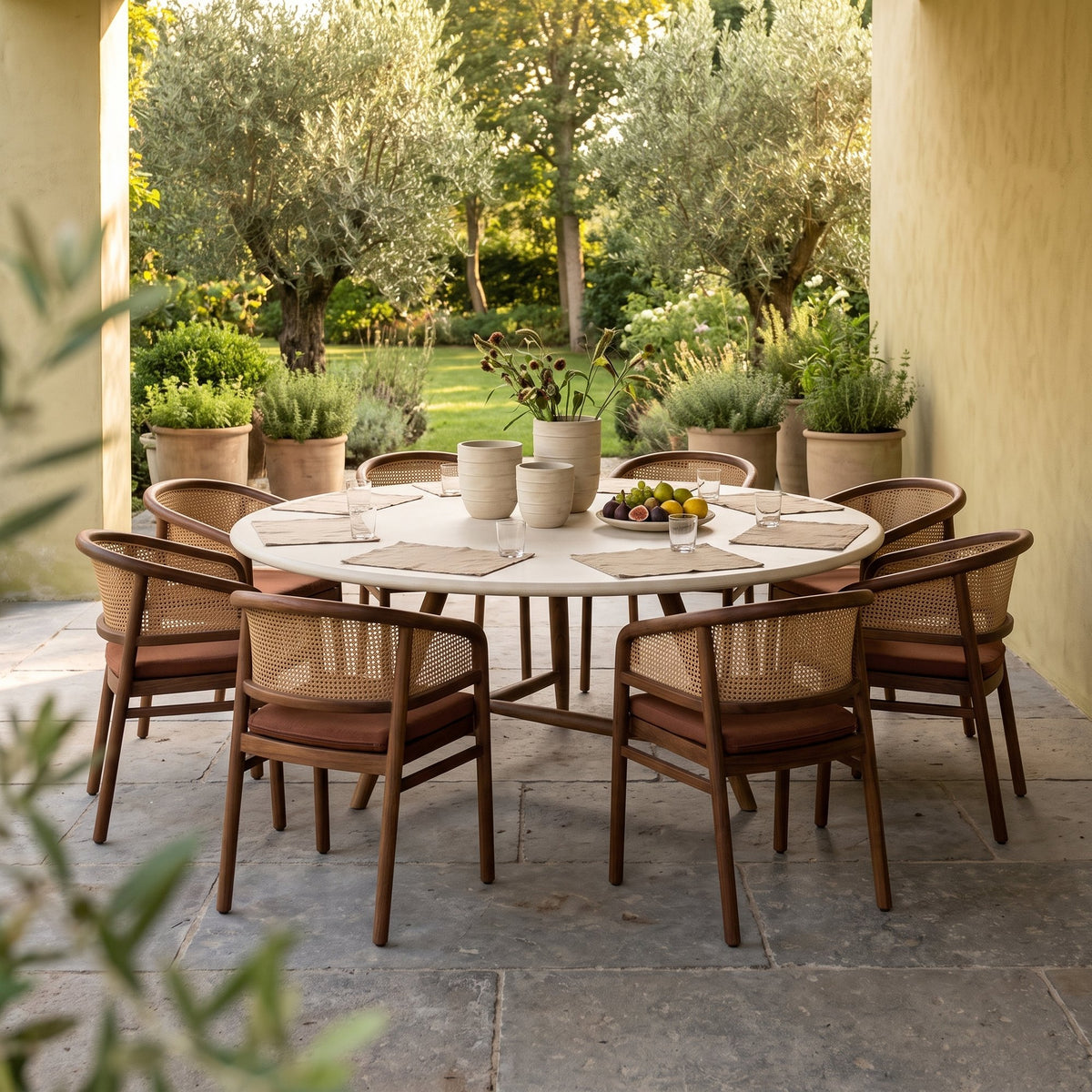 Esstisch Faye rund Beton Teak Emas Brown XL von Gommaire, Beton und Teak Emas Brown, Ø 170 × H 76 cm, Interiorbild mit Armlehnenstühlen Imen und Vase Simon auf der Gartenterrasse