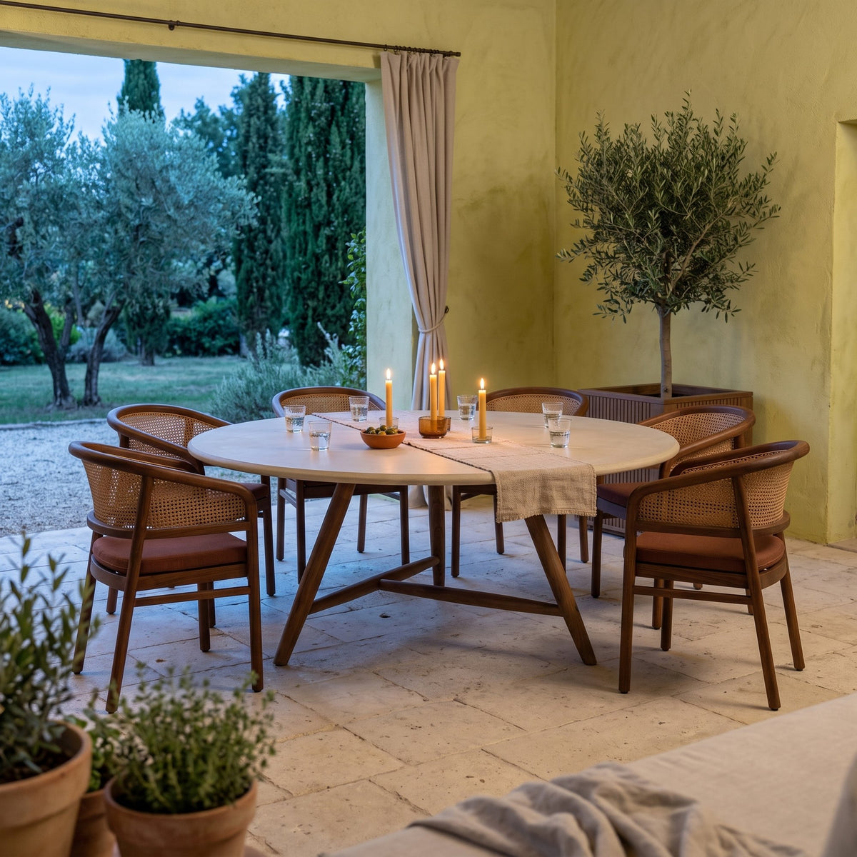 Esstisch Faye rund Beton Teak Emas Brown XL von Gommaire, Beton und Teak Emas Brown, Ø 170 × H 76 cm, Ambiente mit Armlehnenstühlen Imen und Pflanzkübel Nora in der Loggia