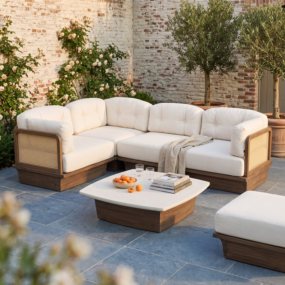 Modulsofa Boa Teak Emas Brown von Gommaire als Ecklounge mit Couchtisch Boa mit Betonplatte Large und Ottomane auf der Terrasse