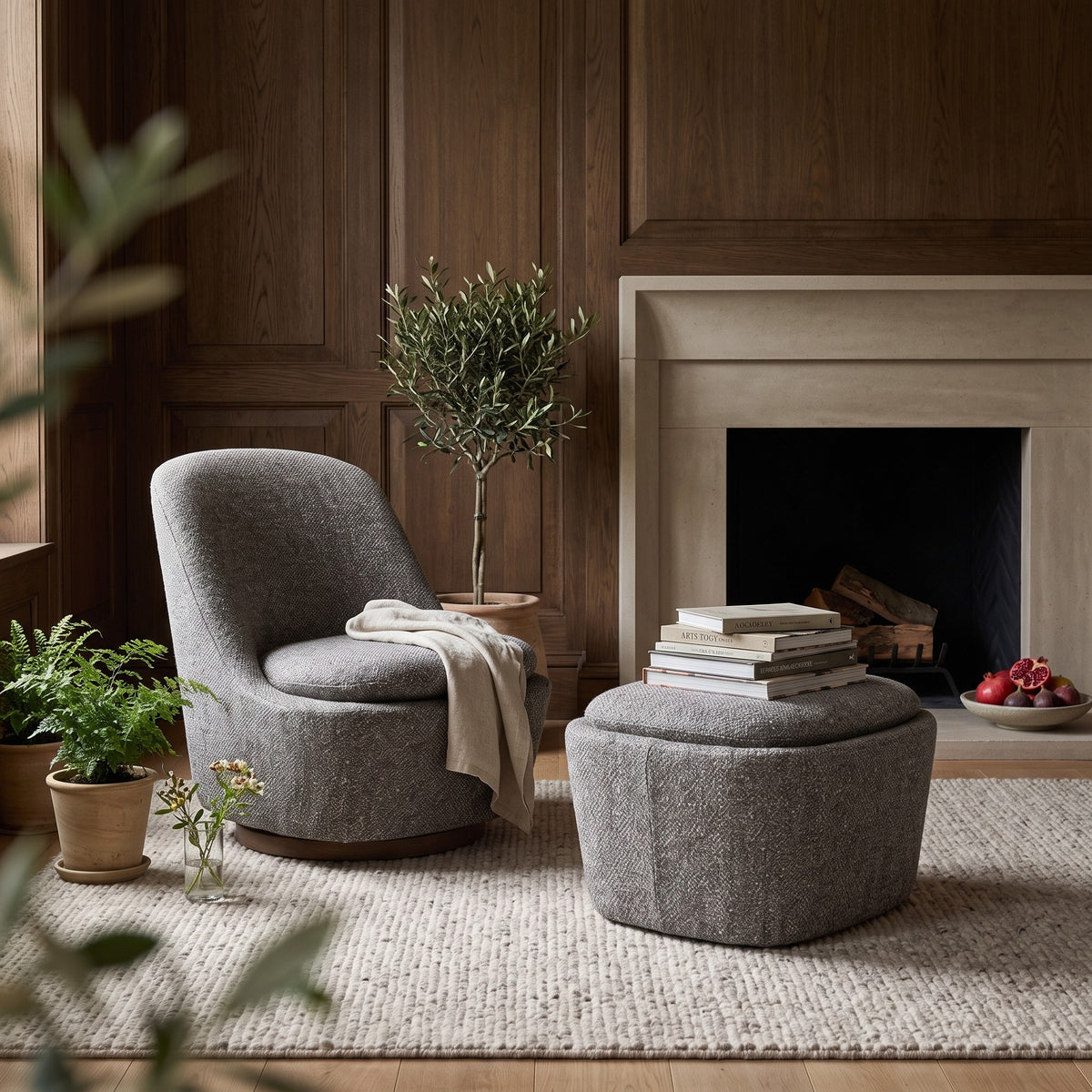 Polsterhocker Liam Stone von Gommaire neben dem Sessel Liam drehbar Stone am Kamin