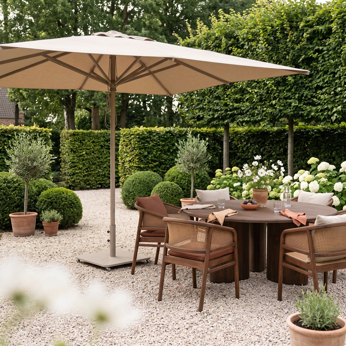 Sonnenschirm Solaya Eukalyptus Natural Grey Brushed Oak Large von Gommaire, Eukalyptus Natural Grey, Bezug Sunbrella Brushed Oak, 325 × 325 cm, H 252 cm, neben dem Esstisch Imen rund mit Armlehnenstühlen Imen im Kiesgarten