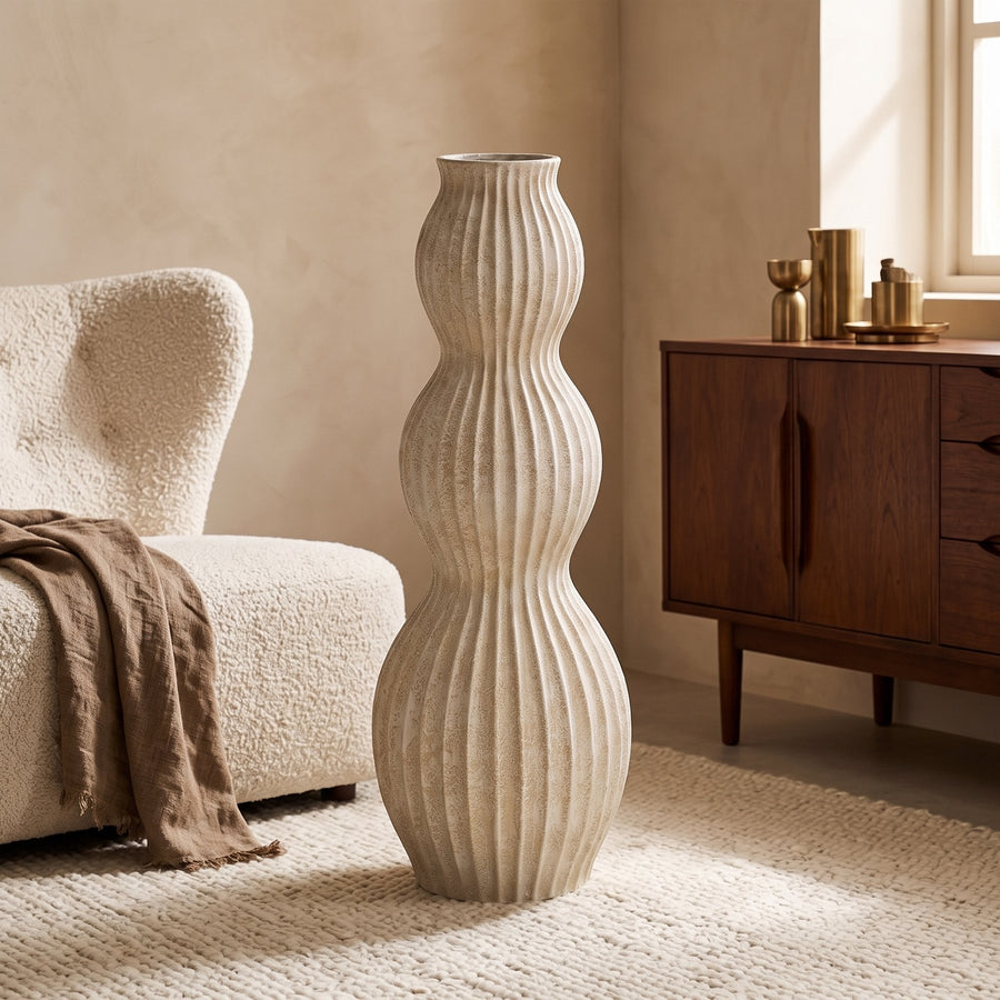 Bodenvase Diede Creme 90 cm neben einem Sessel