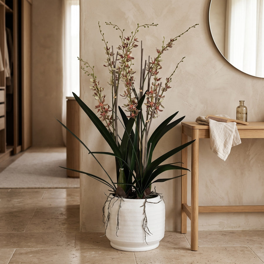 Künstliche rosé Orchidee im Keramiktopf auf einem Konsolentisch