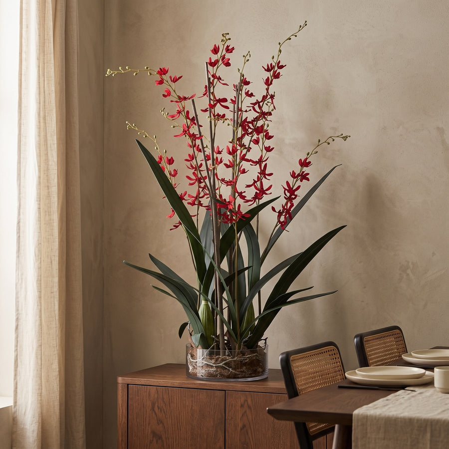 Künstliche rote Orchidee in Glasvase auf einem Sideboard